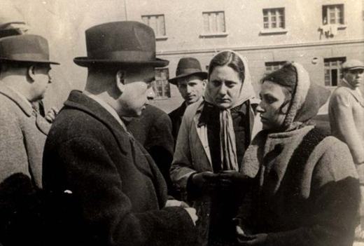 Bulgarian officials speaking with Jewish women who  soon would be transported to Treblinka where they would be killed