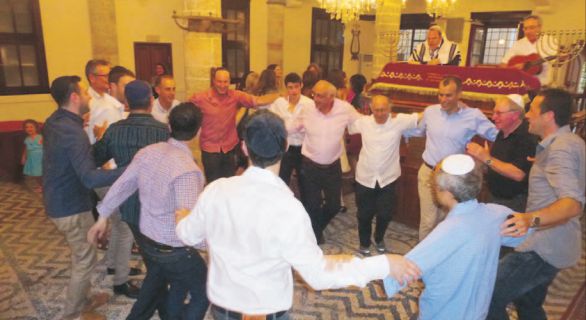 Friends and relatives of the Alhadeff and Gavshon families dance in the 450-year-old synagogue on Rhodes Island during a pre-Kabbalat Shabbat the night before Jonathan Gavshon's aufruf. On the bimah are Sydney's Rabbi David Blackman and Melbourne paediatrician Lionel Lubitz on guitar