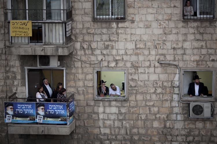 Ariel Schalit/Associated Press (2013) Ultra-Orthodox Jewish men and women watch a ceremony from their Jerusalem balconies on Oct. 13, 2013, a week after the funeral of the religious spiritual leader of Israel’s Sephardic Jews, Rabbi Ovadia Yosef.