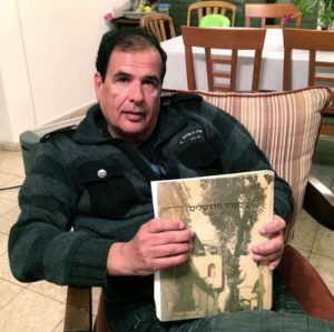 Itzhak Levy, seated in his Jerusalem apartment, holds a copy of a book on his family's history. Levy's ancestors were expelled from Spain. But he says he's not interested in the offer of Spanish citizenship because he doesn't feel that Europe today is supportive of Israel. Ellen Krosney for NPR