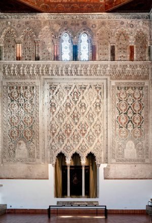 The interior of the 14th-century El Transito synagogue in Toledo, Spain. The synagogue's walls are intricately carved with Hebrew prayers, in marble and gold, and Moorish designs — representing the mix of Jewish and Arab traditions that coexisted in Spain during the Middle Ages. Here you can see the knave of the synagogue, where Torah scrolls were once kept. Courtesy of Museo Sefardí