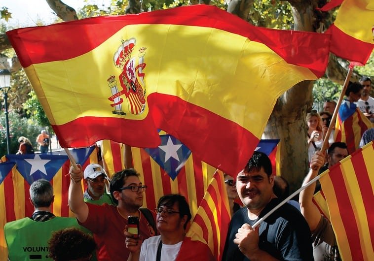 PEOPLE WAVE Spanish and Catalan flags in Barcelona in September. (photo credit:REUTERS)