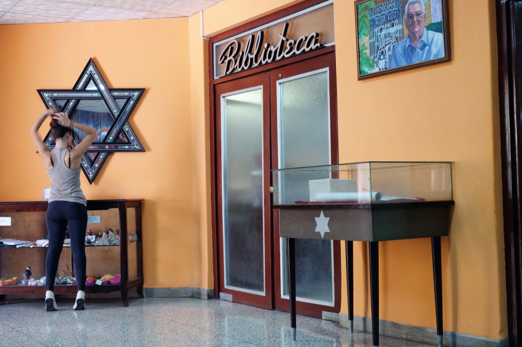 A Jewish girl fixes her hair inside the Beth Shalom administrative building. Aug. 26, 2015, Havana. (Jonathan Alpeyrie)