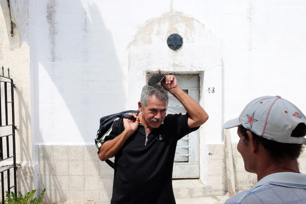 A member of the Jewish community puts on his kippah before entering the Sefarati Jewish cemetery outside of Havana, Sept. 26, 2015. (Jonathan Alpeyrie)