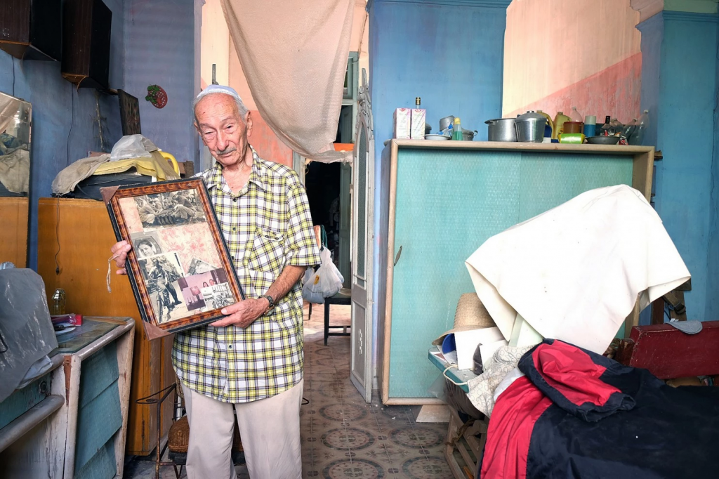 A member of the Sefarati synagogue shows a photograph of his parents, Aug. 31, 2015, in Havana. (Jonathan Alpeyrie)
