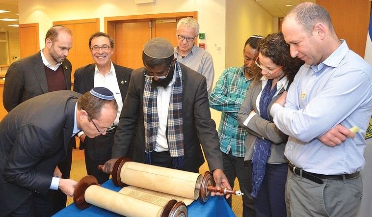 JERUSALEM MAYOR Nir Barkat inspects the Torah scroll donated in memory of Shira Banki to a synagogue in the Katamonim neighborhood. (Jerusalem Municipality)