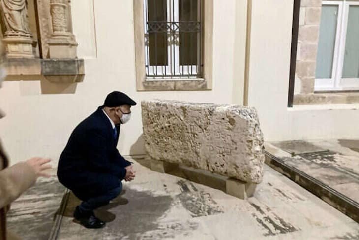 Observando los restos de antiguas lápidas judías.