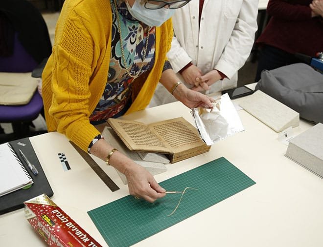 El profesor Boaretto envuelve el espécimen del manuscrito en papel de aluminio para transportarlo al laboratorio del Instituto Weizmann para la datación por radiocarbono.