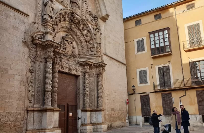 Dani Rotstein, señalando, explica a los turistas alemanes sobre una iglesia que solía ser una sinagoga en Palma de Mallorca, España, el 11 de febrero de 2019.(crédito de la foto: CNAAN LIPHSHIZ/JTA)