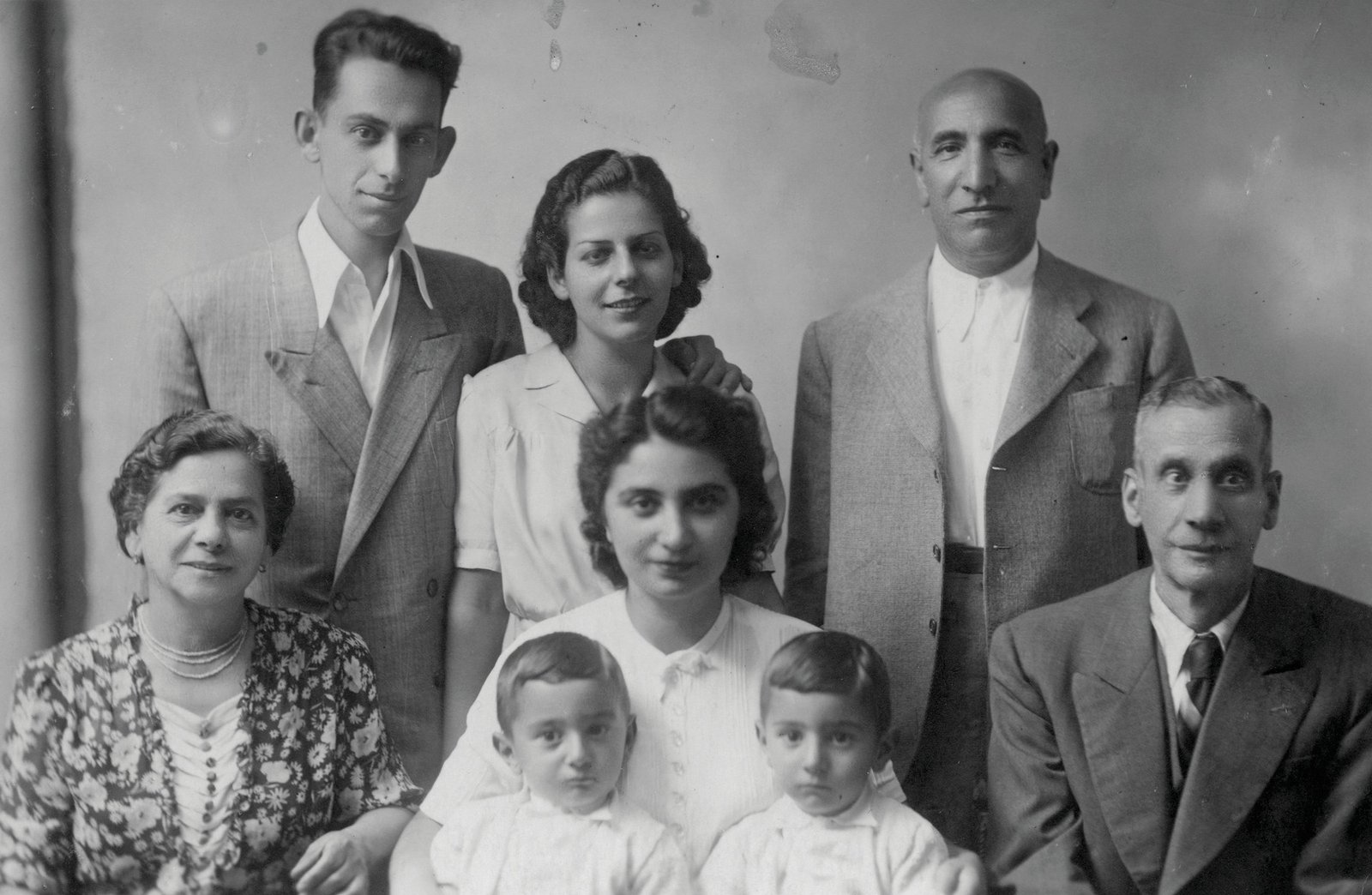 Retrato de grupo de una extensa familia judía que huyó a Italia (1942).En la foto de la última fila, de izquierda a derecha: Chaim Finci, Tilda (Finci) Mosafia y Albert Kabilio.
En la foto de la primera fila, de izquierda a derecha: Rahel Finci, Ella (Kabilio) Finci con sus hijos, Shmuel y Avraham, en sus manos, y Avram Finci.
Crédito de la foto: Museo Conmemorativo del Holocausto de los Estados Unidos, cortesía de Shmuel Finci