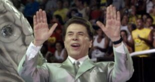 La personalidad televisiva más famosa de Brasil y presentador de varios programas de juegos, Silvio Santos, saluda a la multitud desde lo alto de su carroza para la escuela de samba 'Tradicao' durante un desfile nocturno en el estadio Sambódromo de Río de Janeiro el 25 de febrero de 2001.