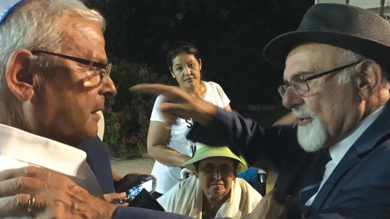 El rabino jefe de Turquía, Ishak Haleva (derecha), habla con un miembro de su congregación en el concierto.( crédito de la foto : ELHANAN MILLER / ISLA BÜYÜKADA )