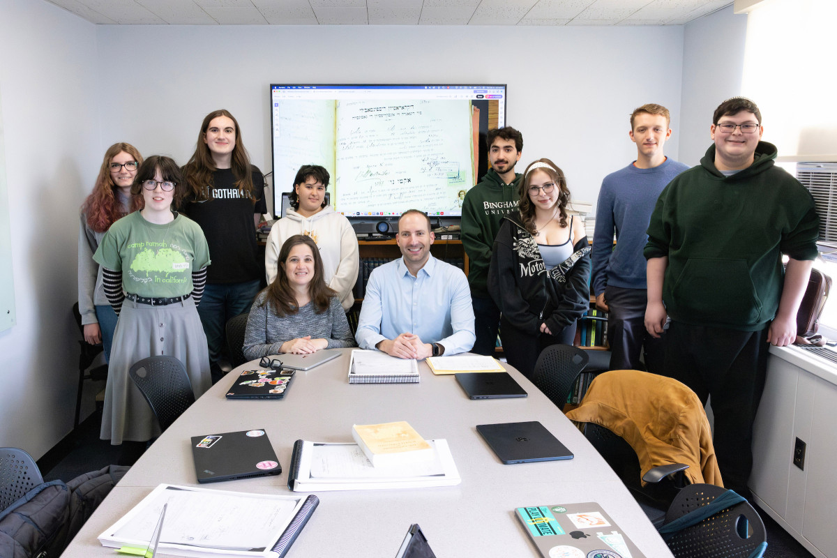Bryan Kirschen, profesor asociado de español y lingüística, y Dina Danon, profesora asociada de estudios judaicos e historia, imparten conjuntamente un curso en el que los estudiantes colaboran con la organización JewishGen para transcribir registros familiares escritos en judeoespañol procedentes de Salónica, Grecia (1934-1935). El grupo que aparece en la fotografía se reúne en la torre de la biblioteca Glenn G. Bartle el 21 de abril de 2026. Crédito de la imagen: Jonathan Cohen.