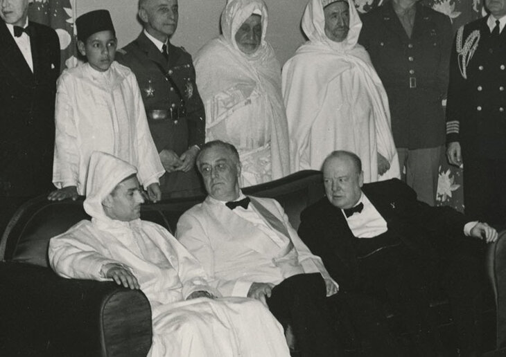 El sultán Mohammed sentado junto a Franklin D. Roosevelt y Winston Churchill durante la Conferencia de Casablanca de 1943; su hijo, el príncipe Hassan, aparece de pie detrás de él.