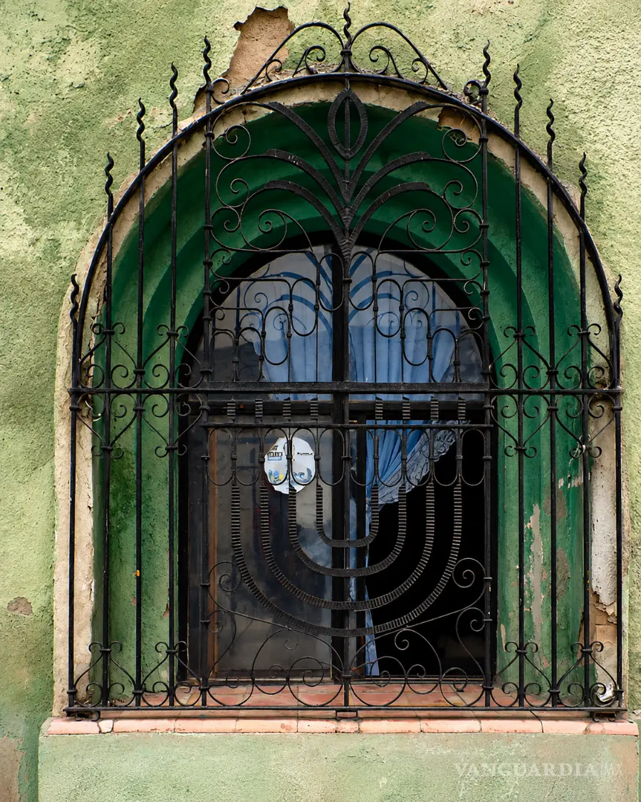 Representación de menorá de nueve brazos en la herrería de una ventana en el Centro Histórico de Saltillo. Calle Acuña. Marzo, 2004.Fotografía de Alejandro Pérez Cervantes y Argelia Isabel Dávila del Bosque